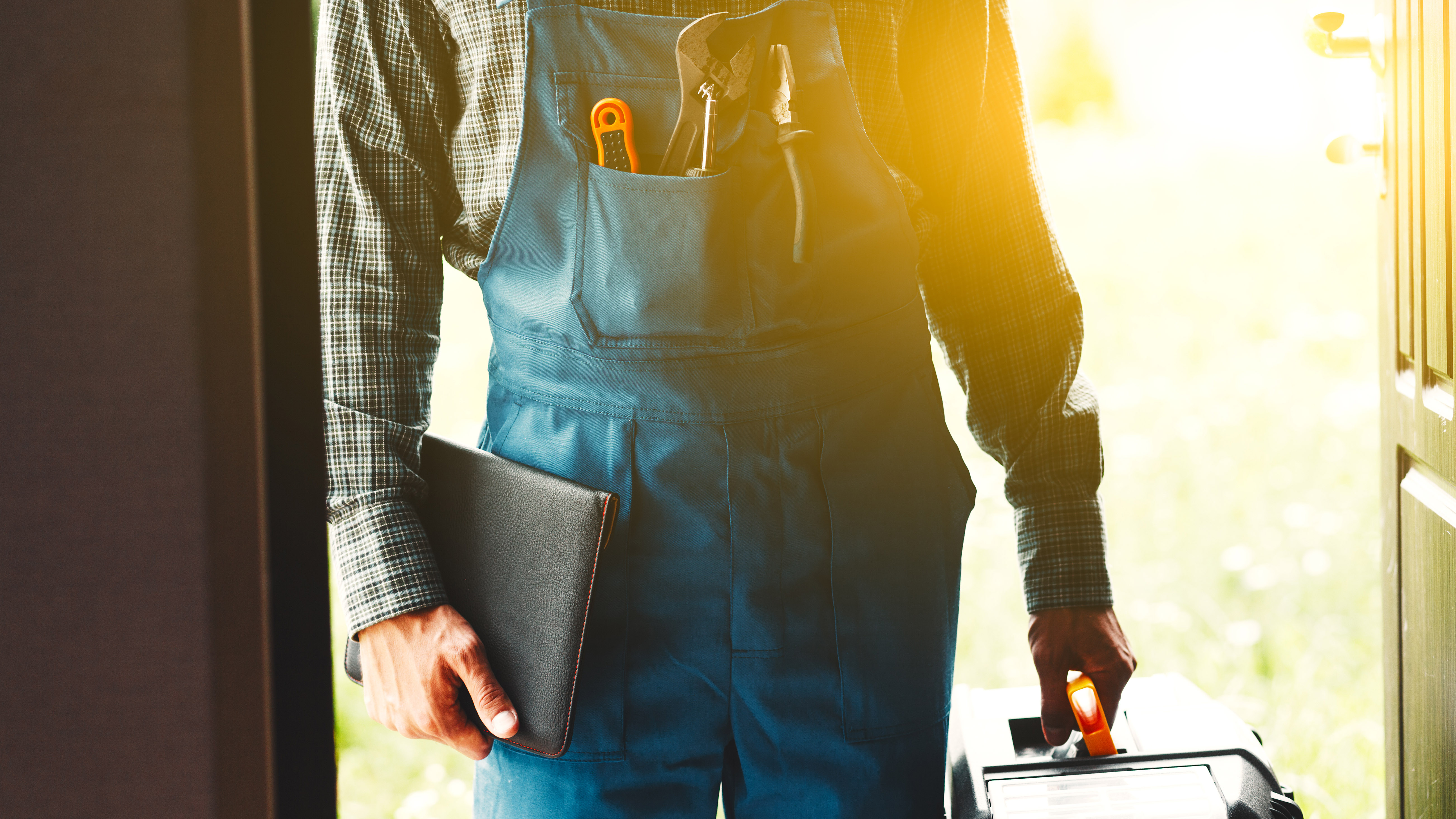 A plumber waiting at the front door of a house