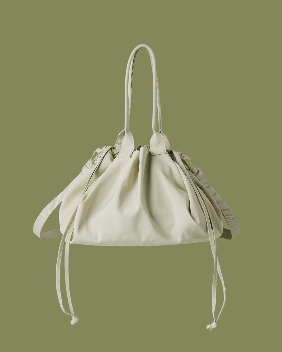 Uniqlo Drawstring Bag against dark green background.