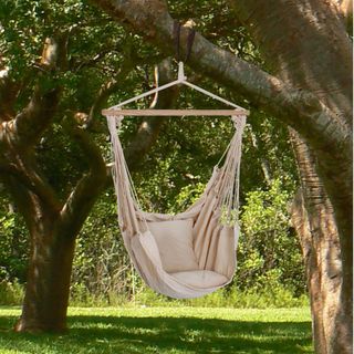 white hanging chair with cushions on trees
