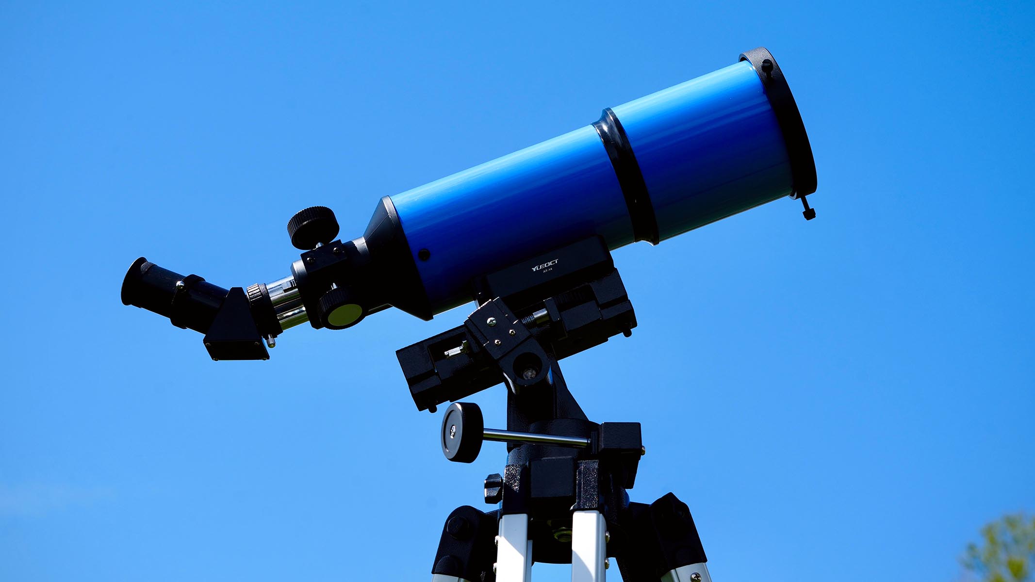 iOptron 80mm white light solar telescope on a tripod against a blue sky