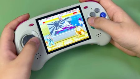 Anbernic Sega Saturn handheld with Street Fighter 2 gameplay on screen