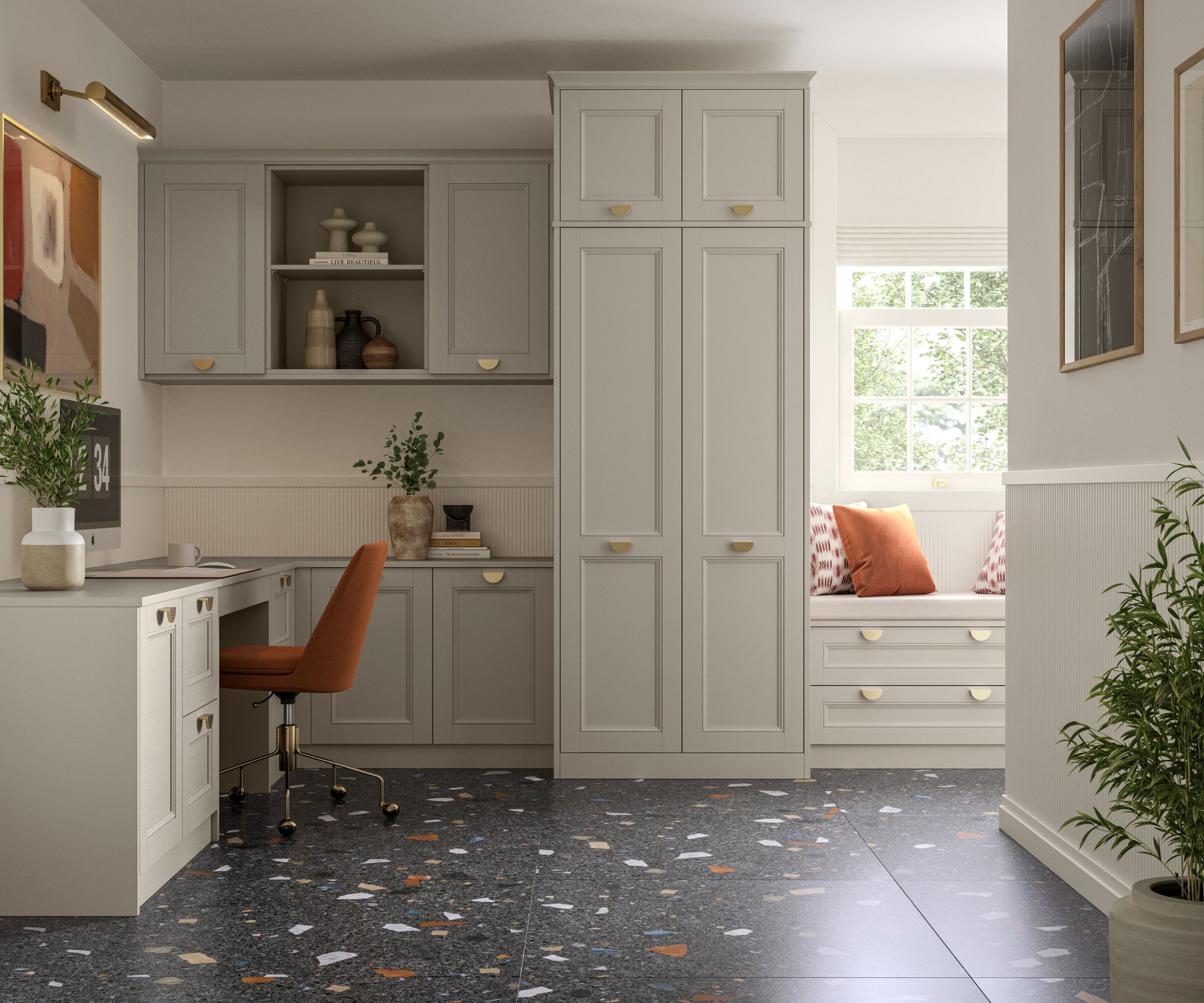 Elegant fitted home office with classic cabinetry in soft grey, a terrazzo floor, rust-coloured chair, built-in window seat, and brass hardware for a warm finish.