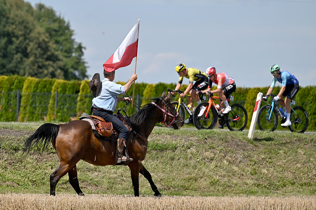 ZAKOPANE, POLAND - AUGUST 08: A general view of the peloton competing while fans cheer riding horses during the 82nd Tour de Pologne 2025, Stage 5 a 206.1km stage from Katowice to Zakopane / #UCIWT / on August 08, 2025 in Zakopane, Poland. (Photo by Luc Claessen/Getty Images)