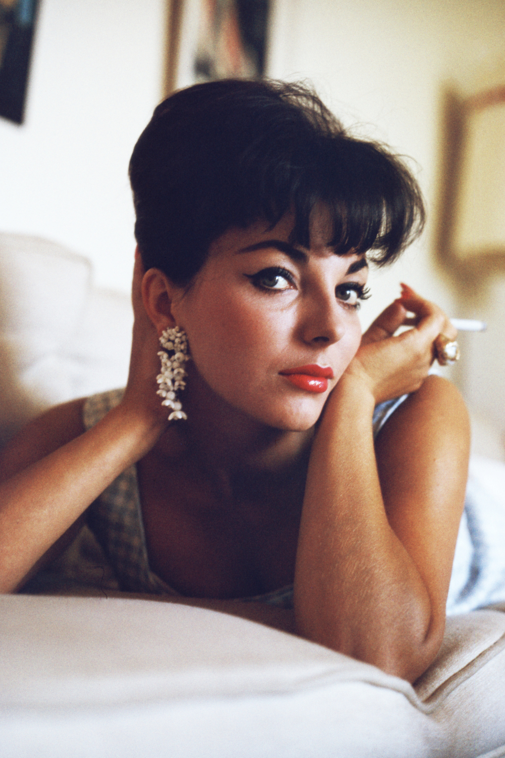 1980s Fashion: Joan Collins portrait image wearing red lipstick and a light blue checkered dress