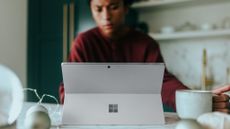 Best 2-in-1 laptops: Man using Windows Surface 2-in-1 laptop with cup of coffee