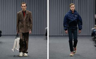 A separate front on view of two different models on the catwalk, the left with a brown coat and red tie, the right in a navy jacket