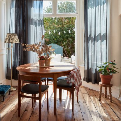 Dining area in bay window with round table and French door to garden