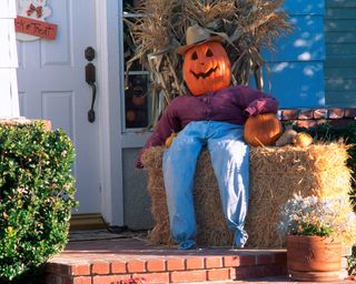 pumpkin scarecrow on porch