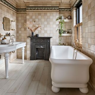 Beige bathroom of tiled walls and ceiling with white bath and double white sink