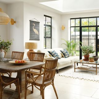 open plan living area with full height crittal-style windows and patio doors, tiled floor and rooflights leading into a dining area