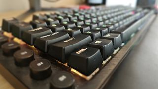 An AOC AGON AGK700 keyboard on a wooden desk