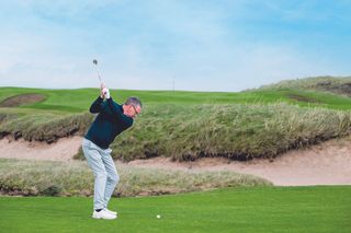 Steve North preparing to hit a short-iron shot into the 10th green, over a fairway bunker at Trump Turnberry