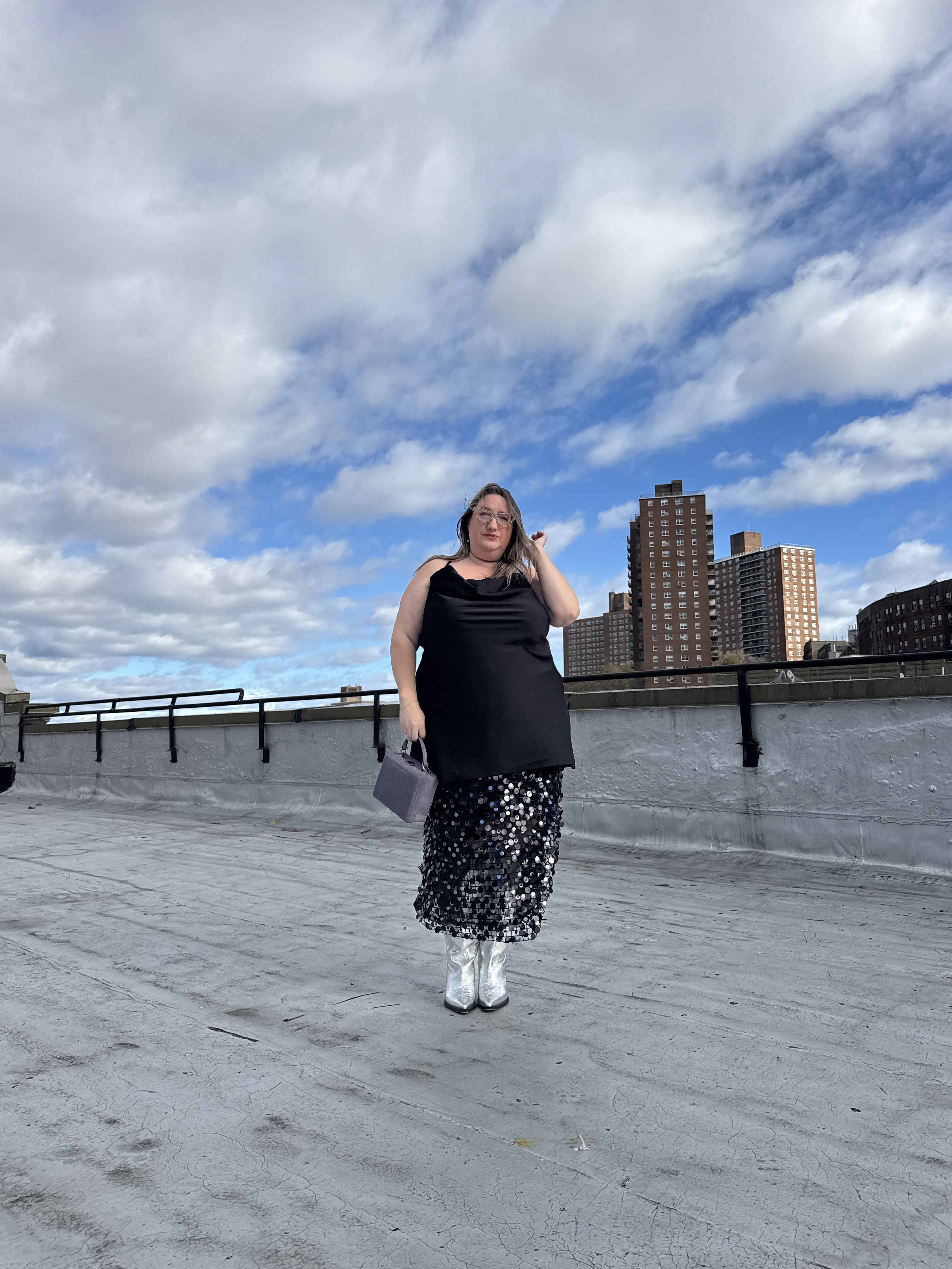 Sarah Chiwaya wearing a little black dress, sequined skirt, and silver boots
