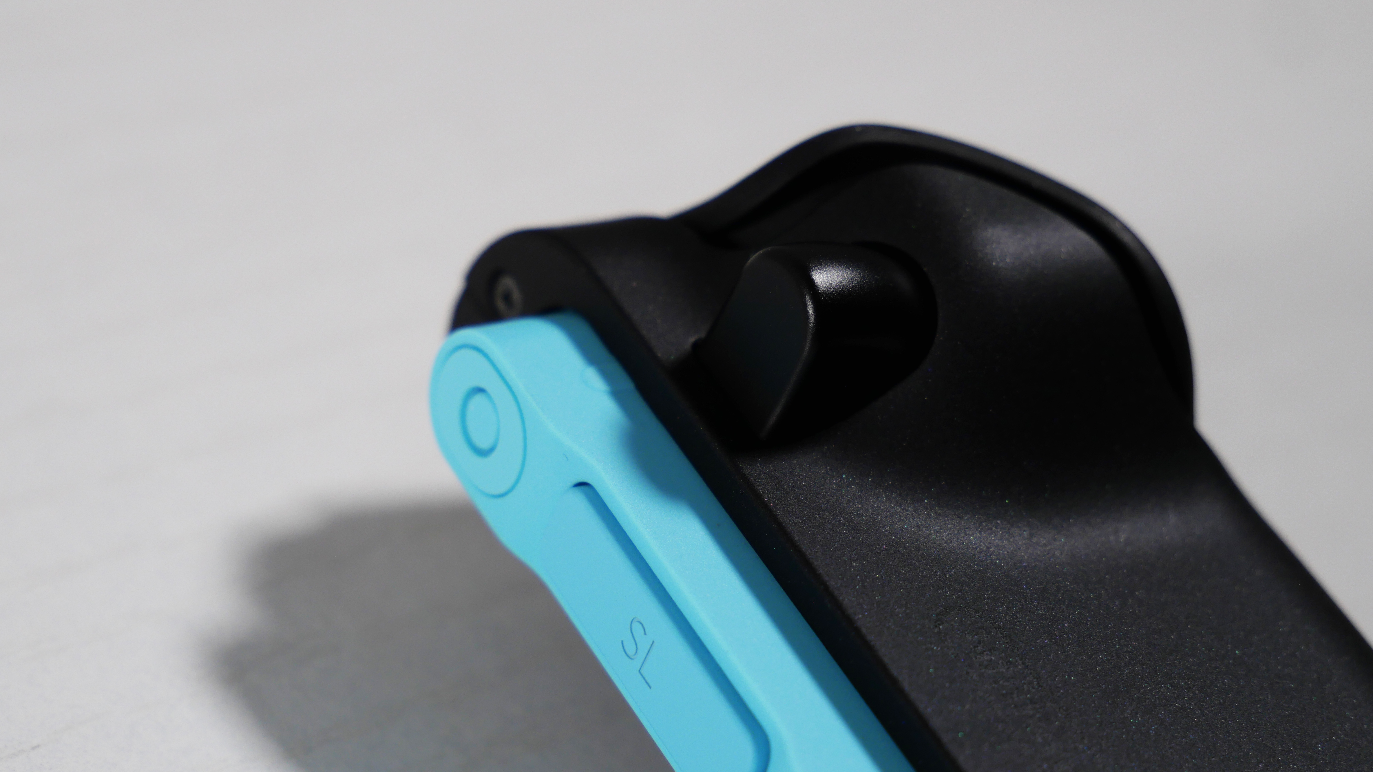 Nintendo Switch 2's Blue Joy-Con 2 on a white desk, highlighting the button to disconnect.