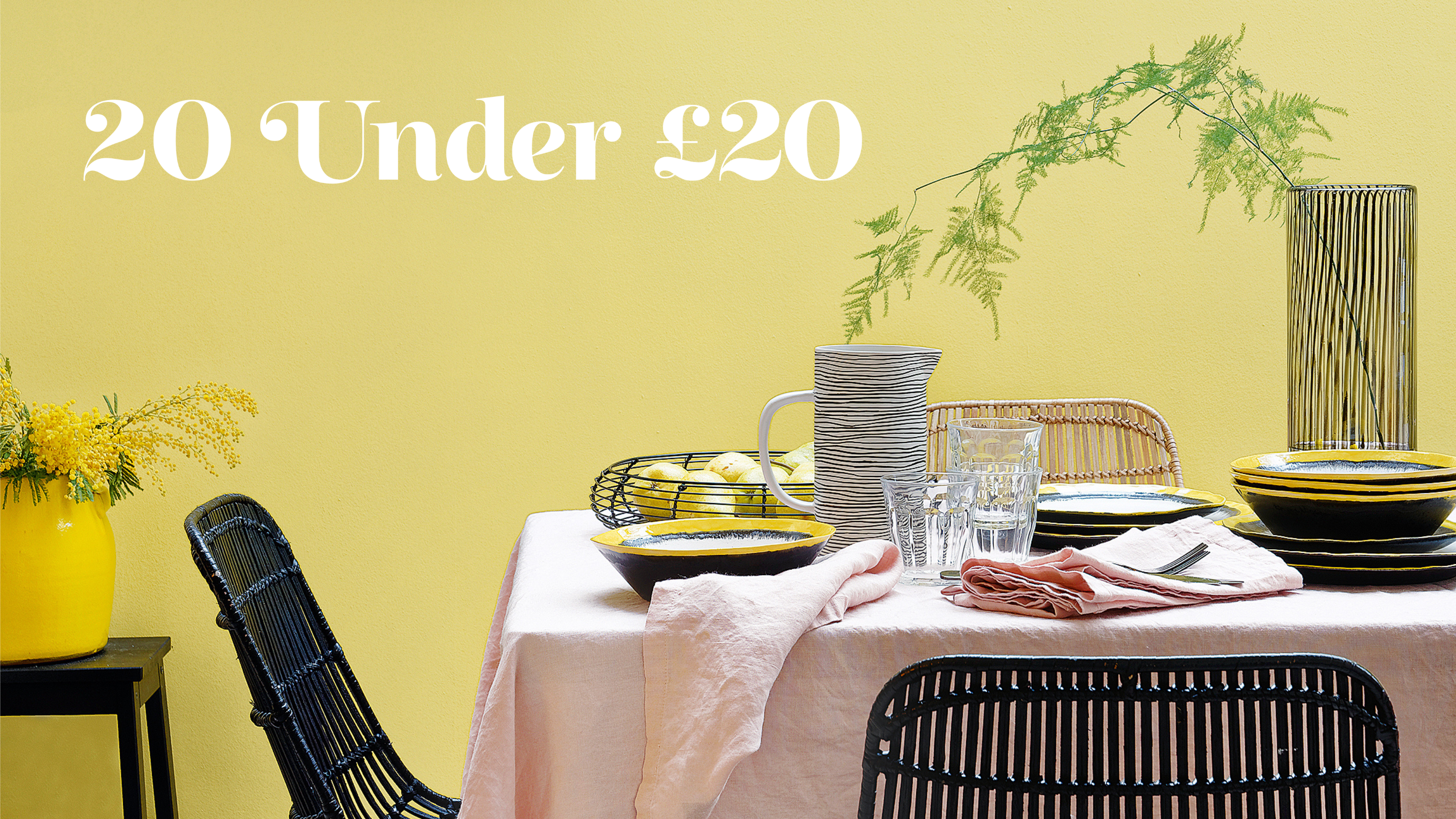 yellow dining room with dining table covered in pale pink table cloth and black chairs