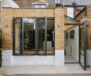 A brick kitchen extension with bifold windows and aluminium framed side door