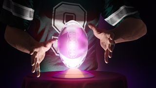 A fan wearing a Tony Romo jersey stares into a crystal ball shaped like a football.
