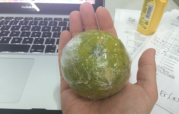 An orange wrapped in cling film
