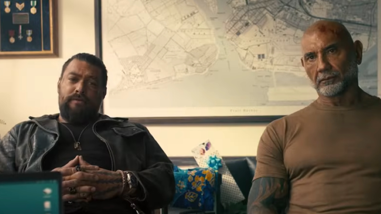 Jason Momoa and Dave Bautista sitting in an office in The Wrecking Crew