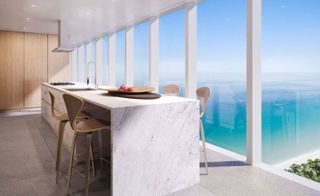 kitchen breakfast bar in a high level luxury apartment with floor to ceiling windows and a view over the blue ocean water