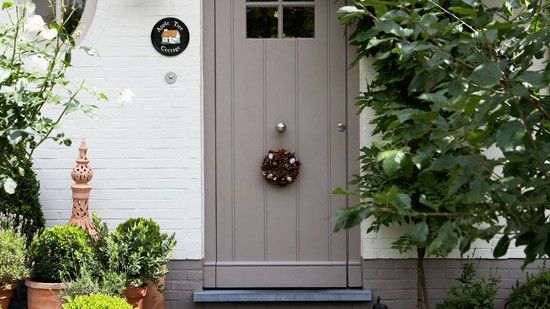 grey door with white brick wall and plants