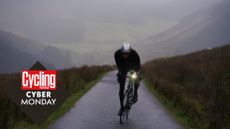 Cyclist riding in the winter with a bike light , with the Cycling Weekly Cyber Monday deals roundal