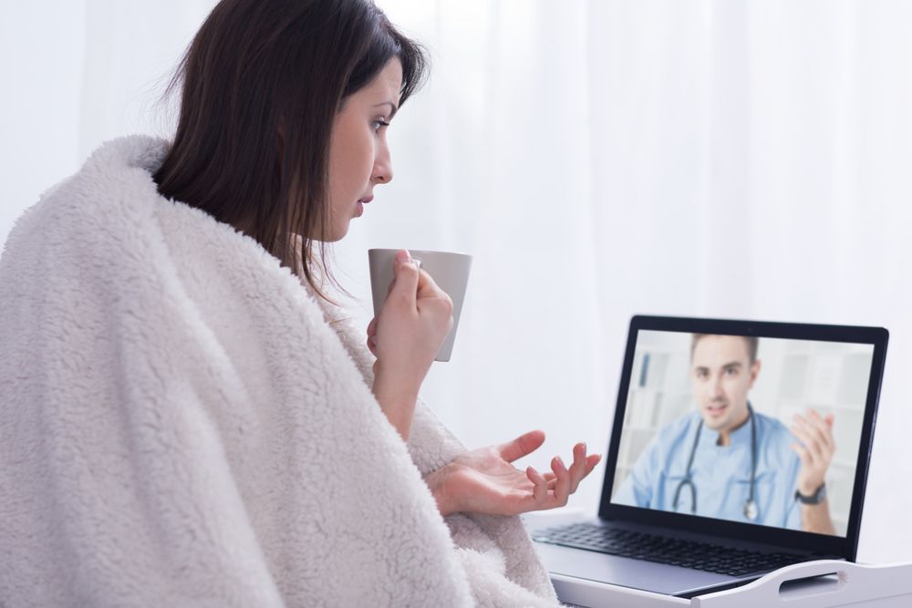 Shot of an unwell woman consulting her GP through a digital NHS service 