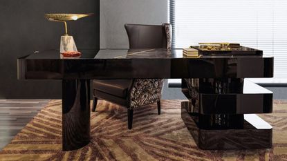 glamorous home office with patterned orange rug, black glossy desk with asymmetrical legs, a tray filled with accessories, a wingback desk chair, and gold sculpture