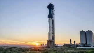 the sun sets behind a giant rocket