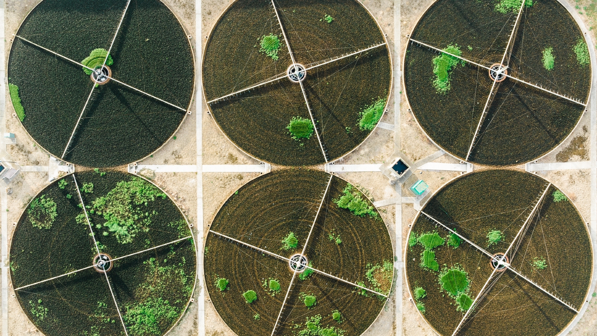 An aerial view of a sewage treatment plant at sunrise.