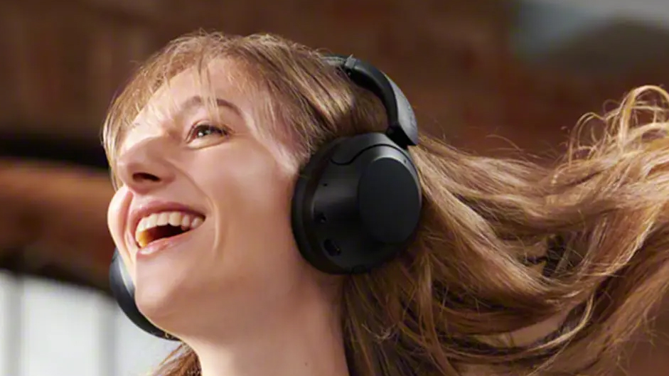 A woman wearing the Sony WH-XB910N headphones