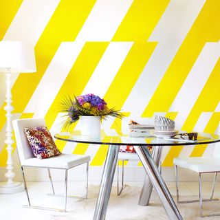 Striped yellow wall with table and chair