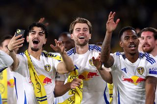 Pascal Struijk, Patrick Bamford and Junior Firpo of Leeds United celebrate promotion to the Premier League at the end of the Sky Bet Championship match between Leeds United FC and Bristol City FC at Elland Road on April 28, 2025 in Leeds, England.