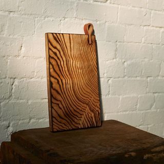 Wooden board on a plynth with white brick wall behind