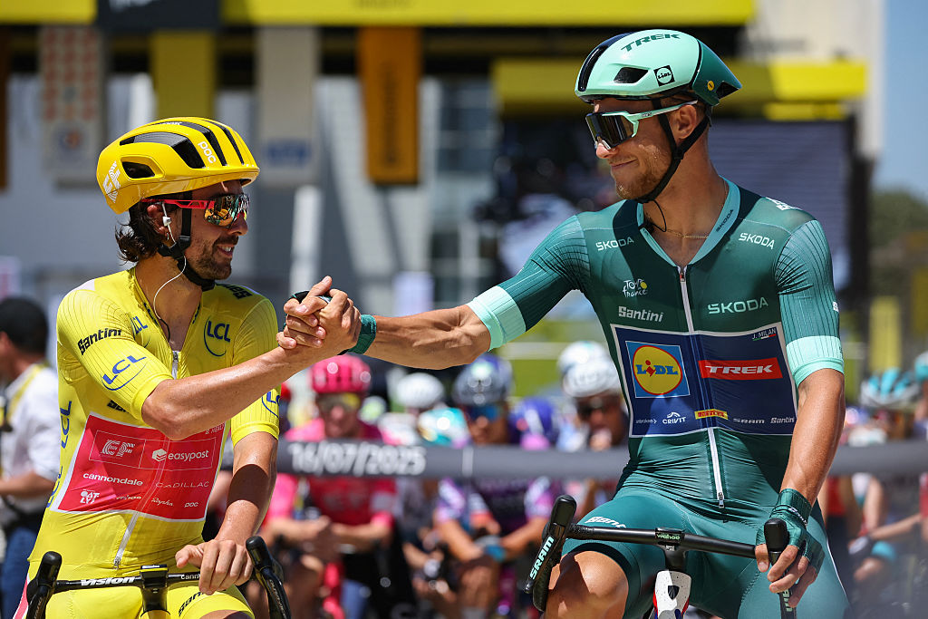 EF Education - EasyPost team's Irish rider Ben Healy (L) wearing the overall leader's yellow jersey shakes hands with Lidl - Trek team's Italian rider Jonathan Milan (R) wearing the best sprinter's green jersey at the start of the 11th stage of the 112th edition of the Tour de France cycling race, 156.8 km starting and finishing in Toulouse, southwestern France, on July 16, 2025. (Photo by Anne-Christine POUJOULAT / AFP) (Photo by ANNE-CHRISTINE POUJOULAT/AFP via Getty Images)