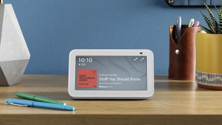 Amazon Echo Show 5 playing a podcast on a writing desk