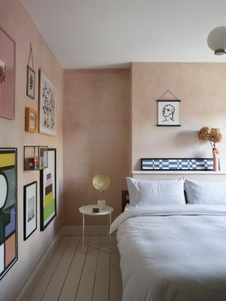 Bedroom with plaster pink textured walls and gallery wall art