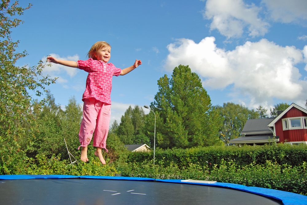 A girl bounces on a trampoline