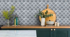 Gray scalloped kitchen wall tile ideas by Ca'Pietra, with a wooden shelf, chopping board and small vases of foliage.