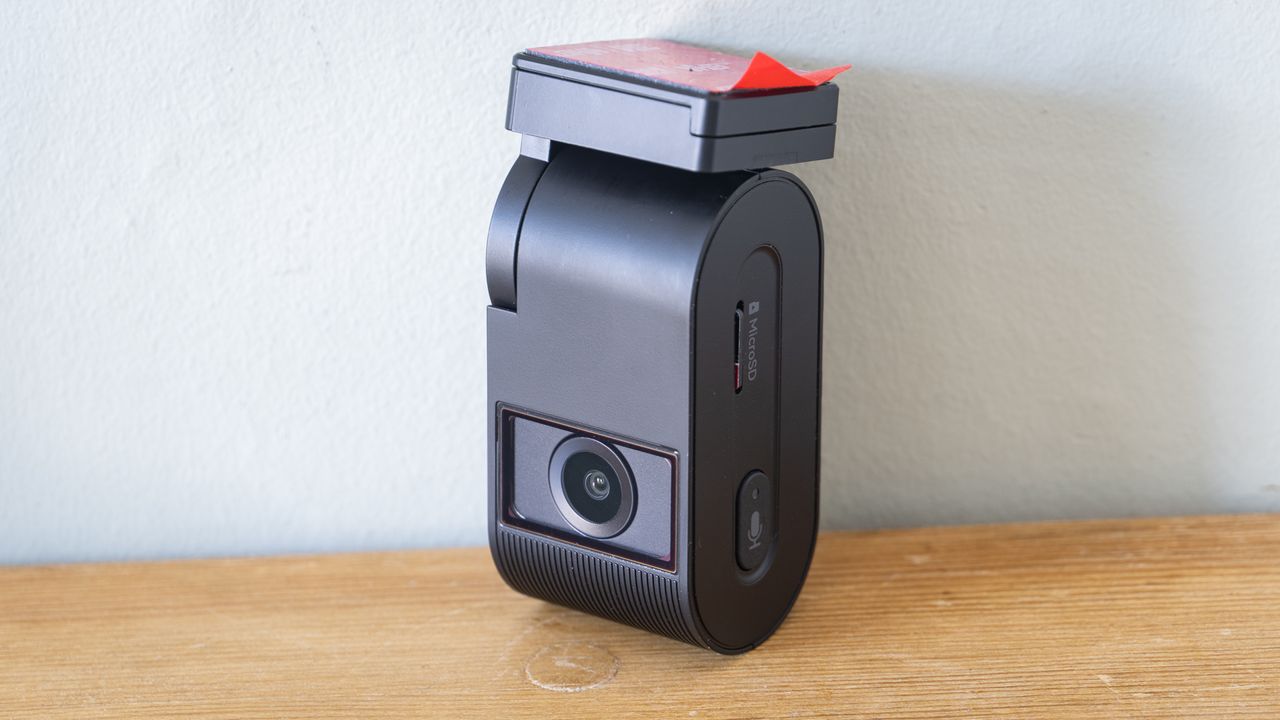 Viofo VS1 dashcam on a wooden table in front of a white wall
