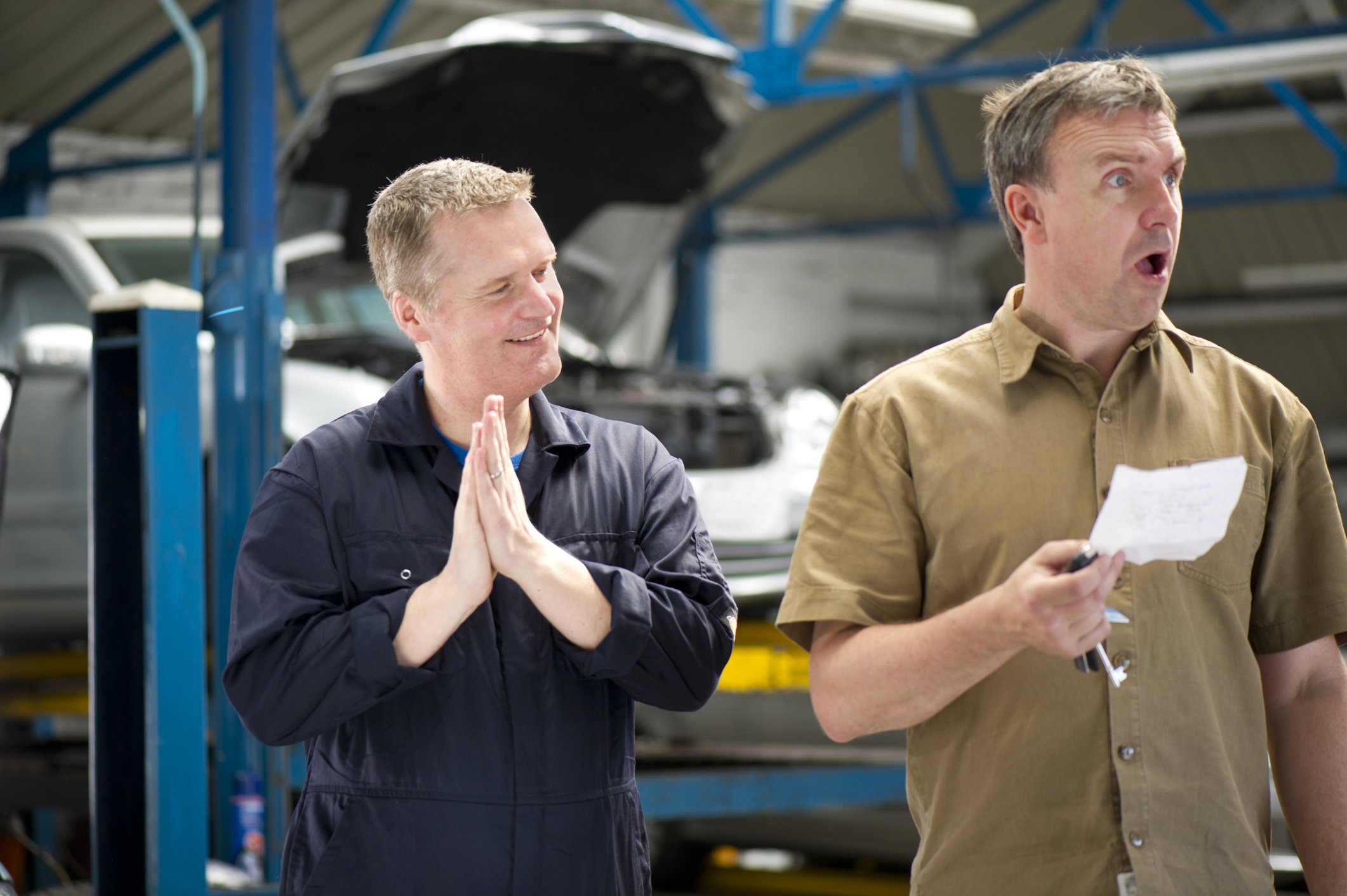 a picture of a man surprised by a car repair bill