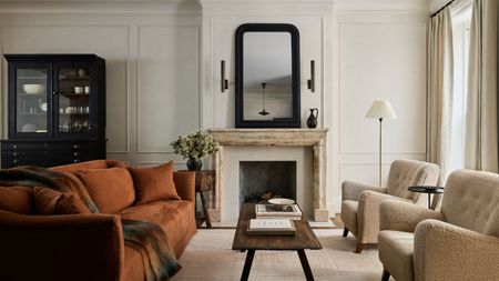 living room with stone fireplace, terracotta couch, timber coffee table, beige armchairs, hutch cabinet