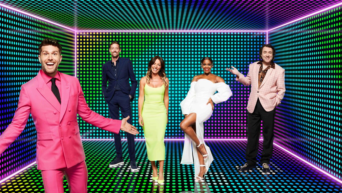 A composite shot of The Masked Dancer&#039;s panellists, all wearing colourful outfits and standing in a disco-esque room filled with dots of various bright colours. From left to right: Joel Dommett, Peter Crouch, Davina McCall, Oti Mabuse and Jonathan Ross