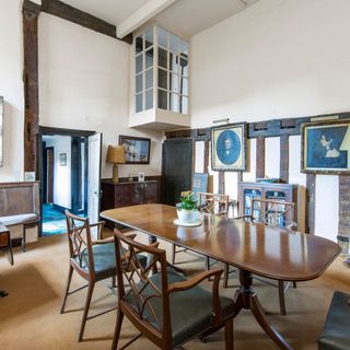 dining room features slightly higher ceilings, wooden panelling and beams running across the walls