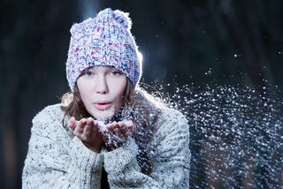 a woman blowing snow