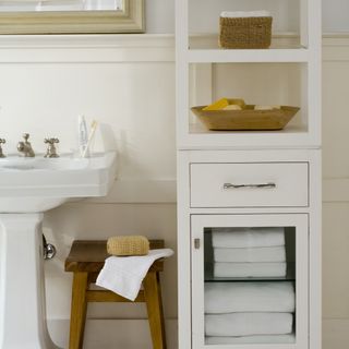 freestanding white bathroom cabinet next to the sink