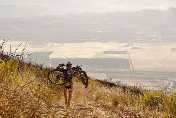 A Rider carries his bike