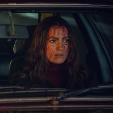 Ben Whishaw as Sam and Keira Knightley as Helen, sitting in the front seats of a British car (with blood on Helen's face), in 'Black Doves.'