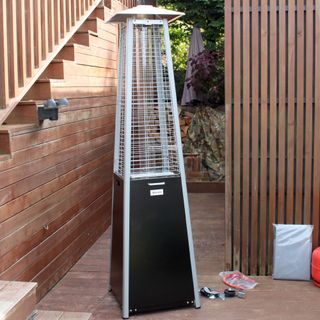 The Outsunny 11.2kw Pyramid Gas Patio Heater being unboxed and tested on a wooden deck