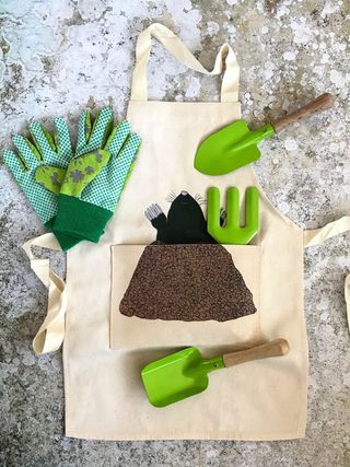 Kids garden set including apron and mini tools include a trowel, fork and spade